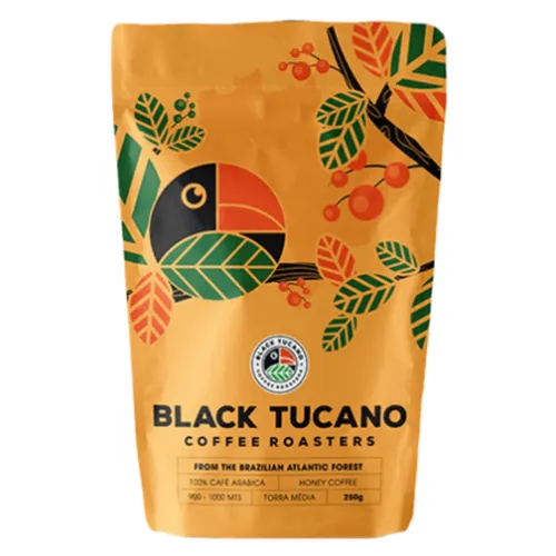 Pacote de café em grão amarelo com ilustração de um tucano