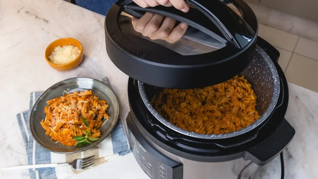 Pessoa cozinhando feijão em panela de pressão elétrica