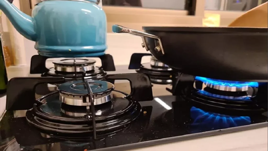 Mulher cozinhando com cooktop 4 bocas