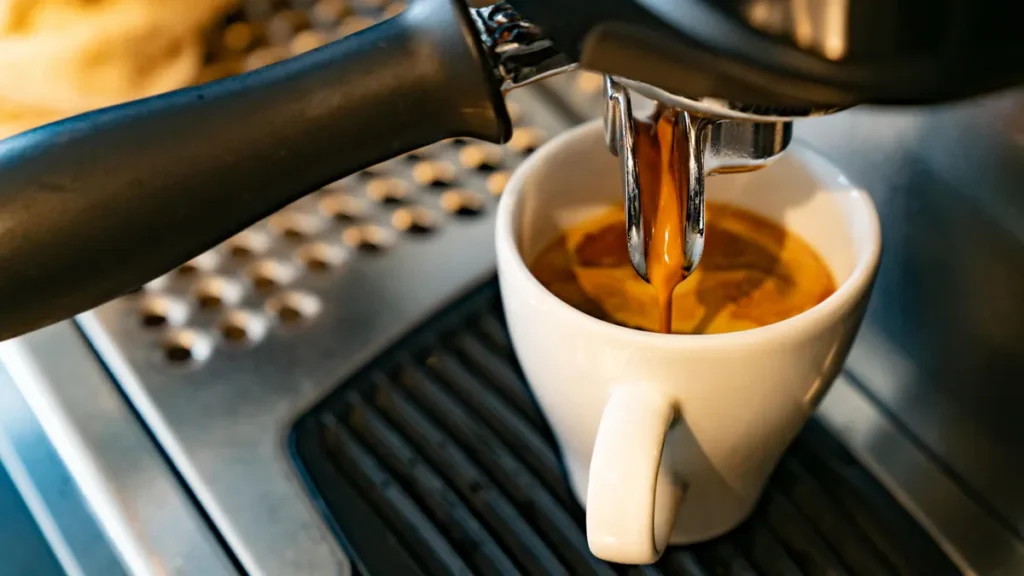 Café sendo extraído de cafeteira expresso