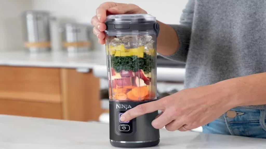 Mulher preparando vitamina com mini liquidificador portátil